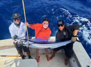 a group holding a fish on a fishing boat