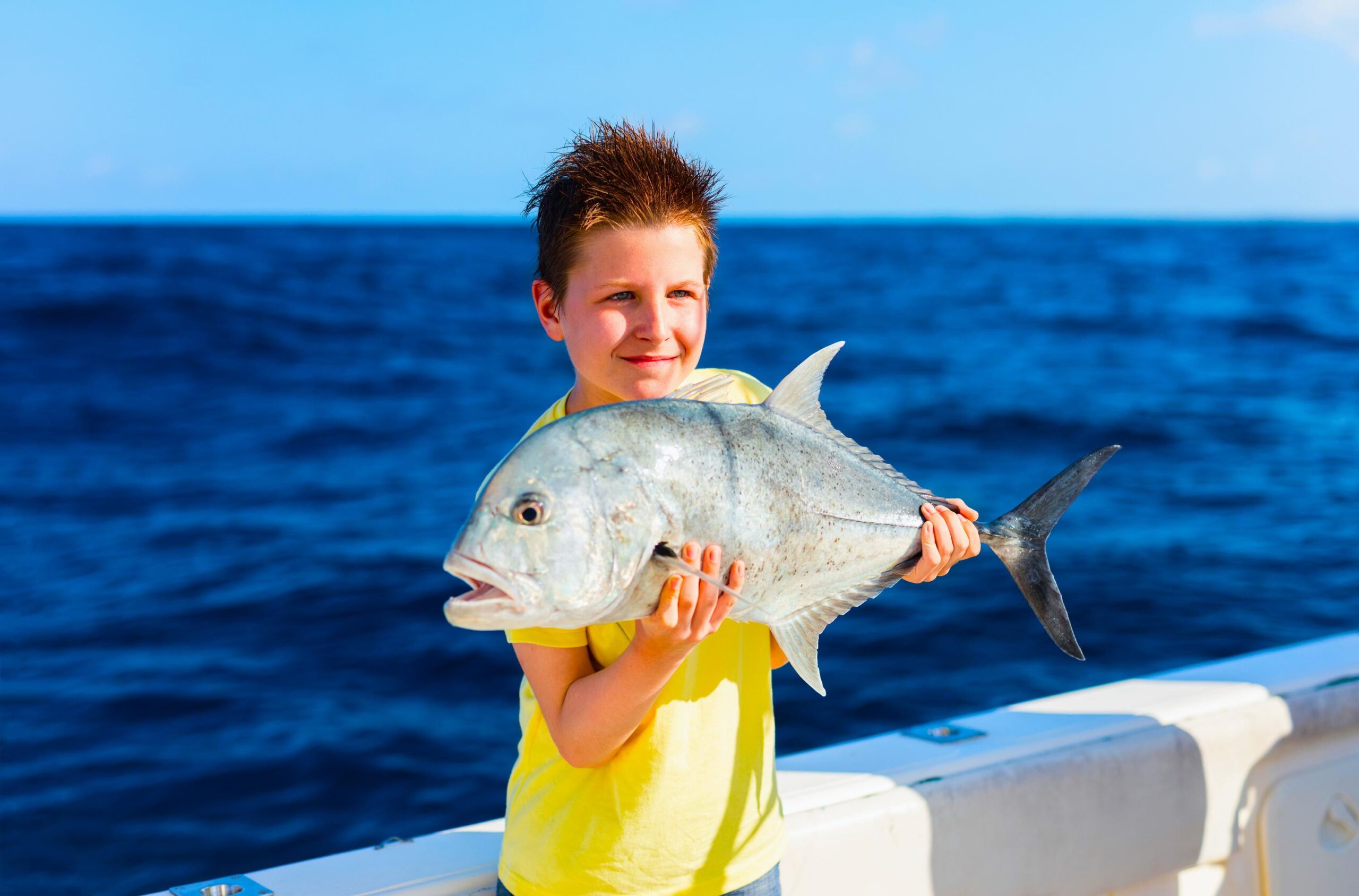 a boy holding a fish he caught