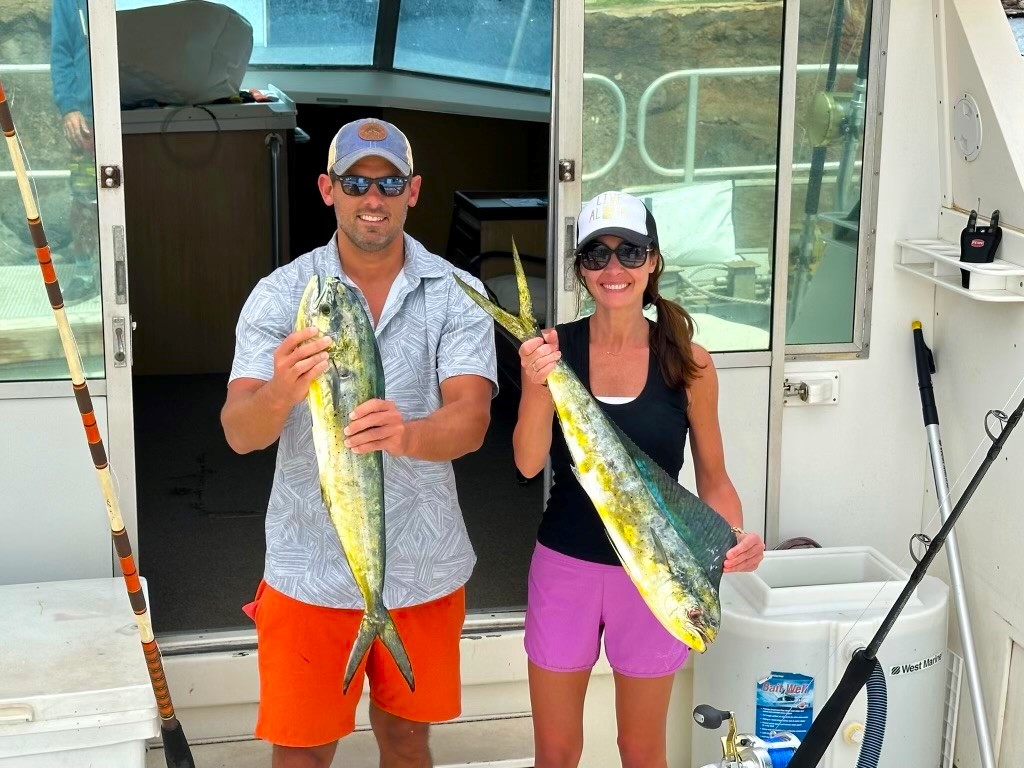 two people holding up their fishes