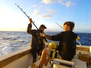 two people with fishing poles on a boat